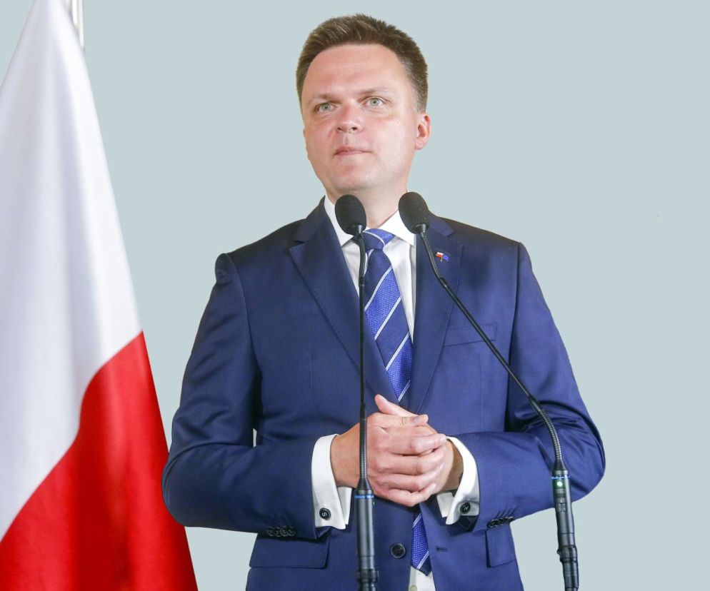 Szymon Hołownia przemawia przy mikrofonach. O jego możliwym powrocie do rządu przeczytasz na SE Polityka.