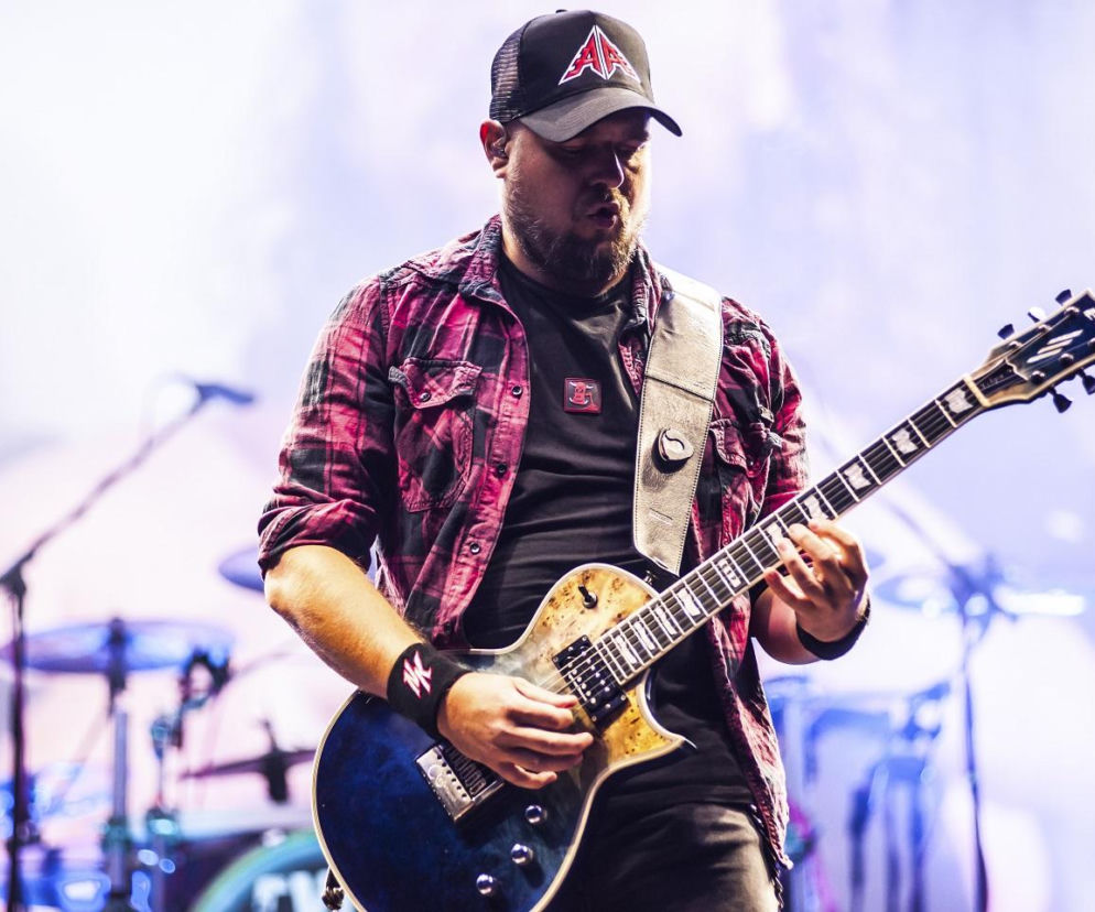 Gitarzysta Robert Kazon Kazanowski gra na gitarze podczas koncertu. O jego odejściu z zespołu przeczytasz na EskaRock.
