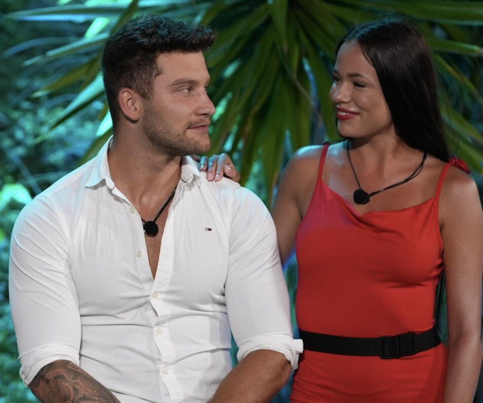 Magda i Andrzej z programu Hotel Paradise w intymnym kadrze, Magda trzyma dłoń na ramieniu Andrzeja. Ich spojrzenia wyrażają zażyłość i emocje. Więcej o ich relacji przeczytasz na Super Seriale.