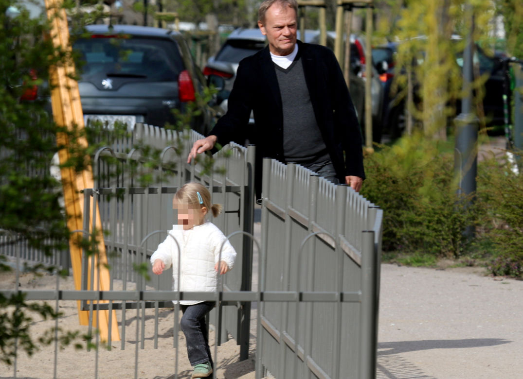 Donald Tusk z wnuczka na placu zabaw