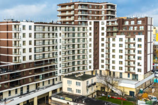 Dom otoczony blokiem przy ul. Bacha 35 w Warszawie