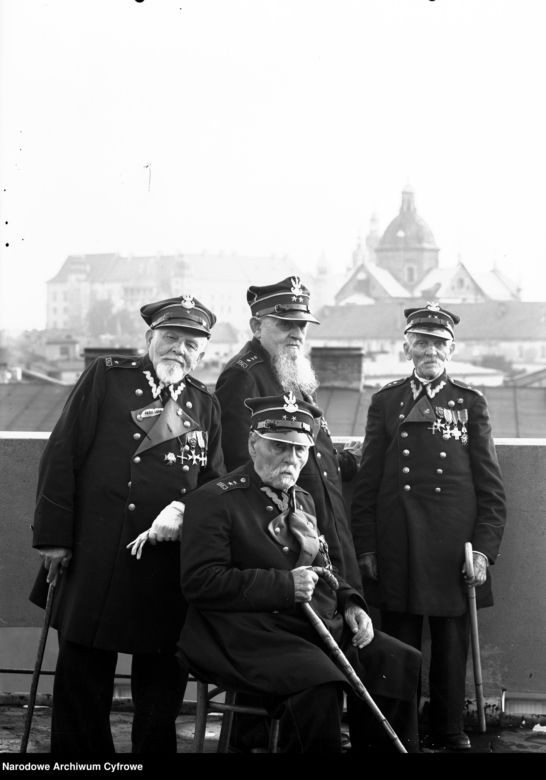 Weterani powstania styczniowego na dachu Pałacu Prasy. Siedzi Wiktor Malewski. Stoją od lewej: Antoni Suss, Mamert Wandali, Walenty Milczarski. 