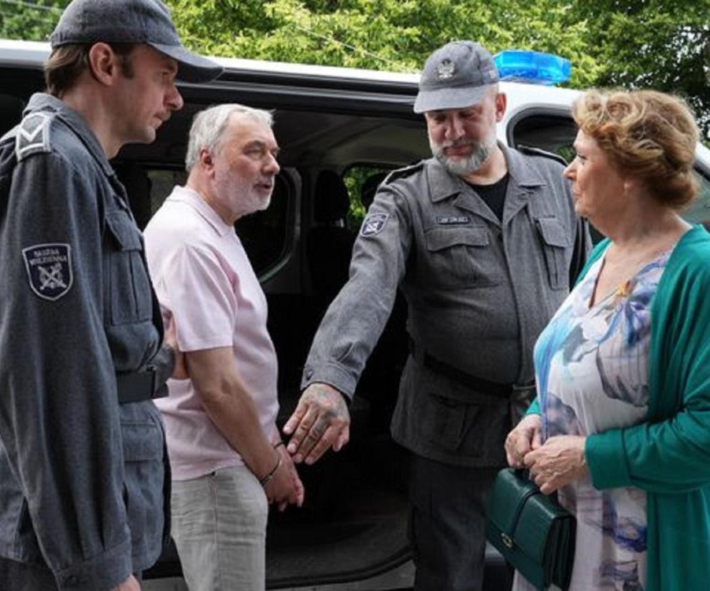 Andrzej (Leon Charewicz) eskortowany przez strażników więziennych do aresztu, spotyka Józefinę (Elżbieta Jarosik), która patrzy na niego z wyraźnym żalem. Scena z serialu Barwy szczęścia dostępna na Super Seriale.