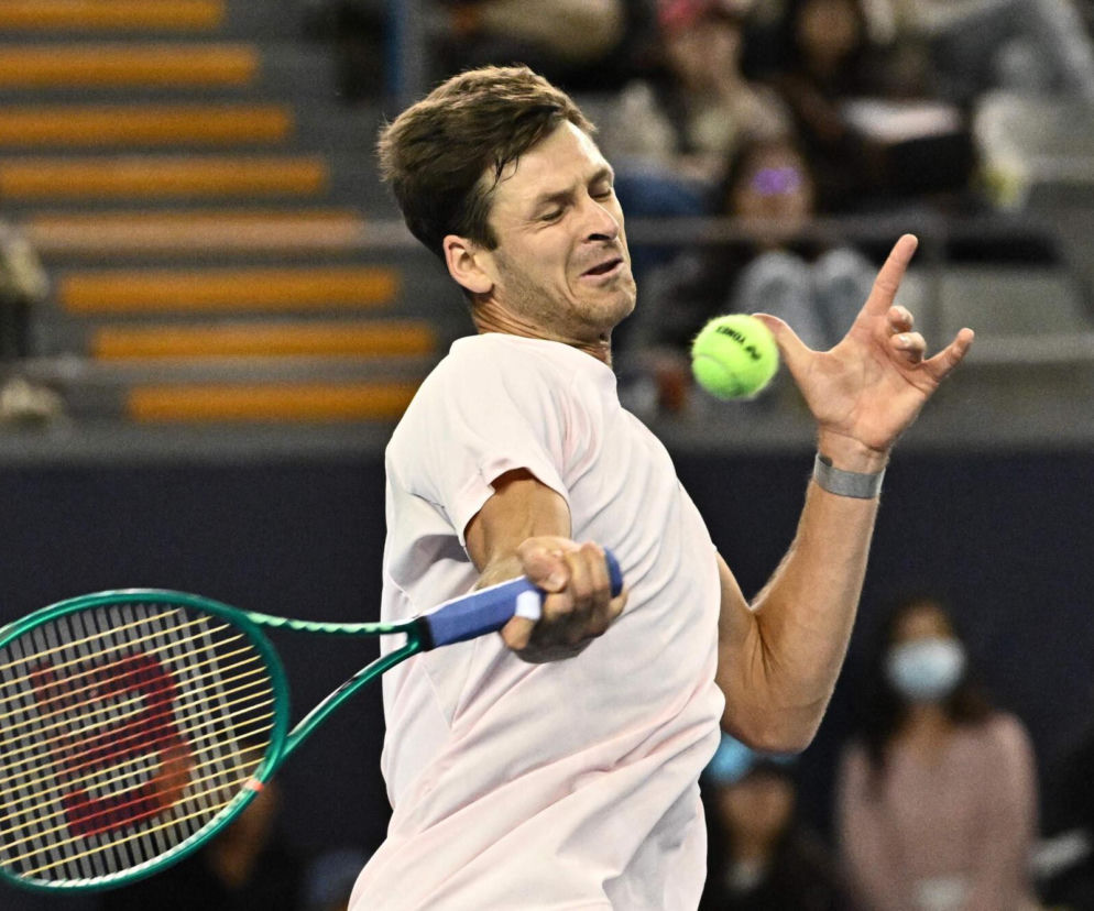 Hubert Hurkacz z wysiłkiem uderza rakietą w piłkę tenisową. O nagrodach w ATP Bazylea przeczytasz na SE Supersport.