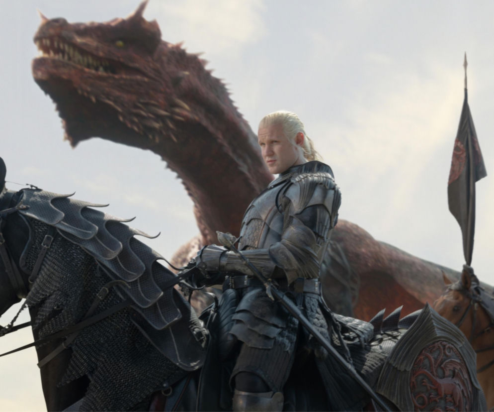 Daemon Targaryen w zbroi na koniu. W tle wielki czerwony smok. O finale serialu Ród smoka przeczytasz na SE.