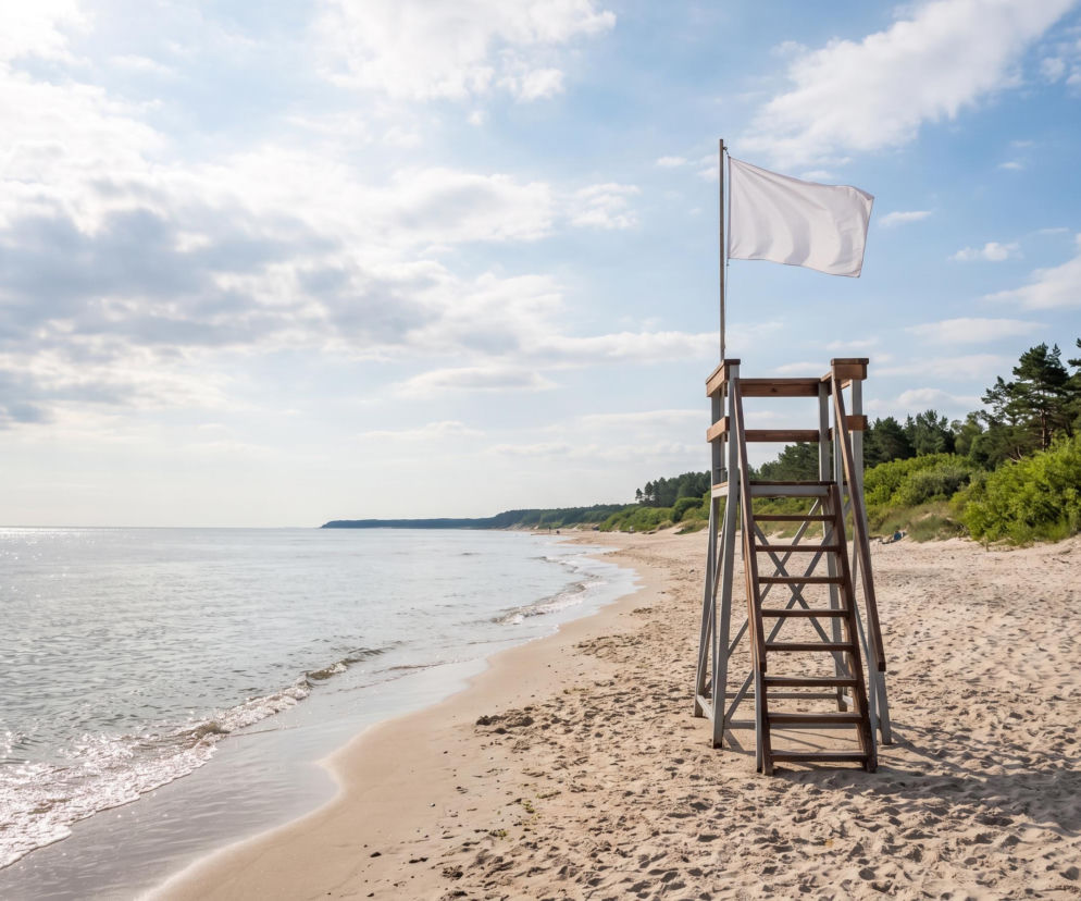 Wieża ratownicza z białą flagą na pustej plaży w Chłopach. O bezpiecznej kąpieli przeczytasz na SE Szczecin.