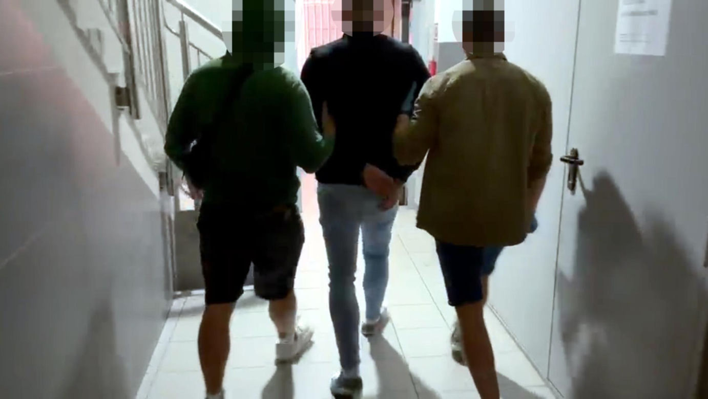 Policjanci prowadzący zatrzymanego