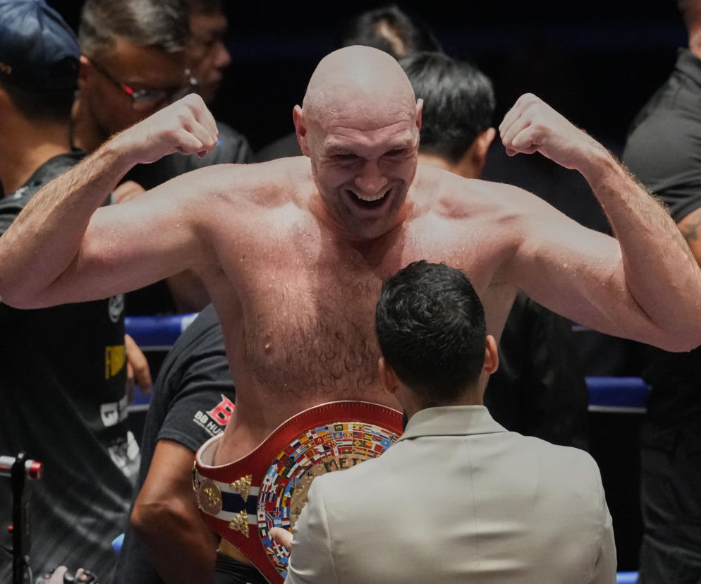 Radosny Tyson Fury z pasem mistrzowskim napina bicepsy po walce. O starciu z Joshuą przeczytasz na SE Supersport.