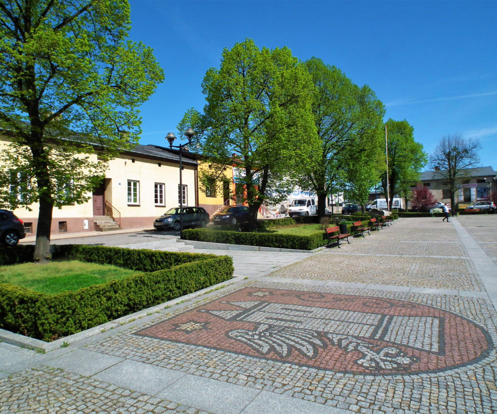 Rynek w Krzepicach z widocznym herbem miasta ułożonym z kostki. O historii tego miejsca przeczytasz na Eska Śląskie.