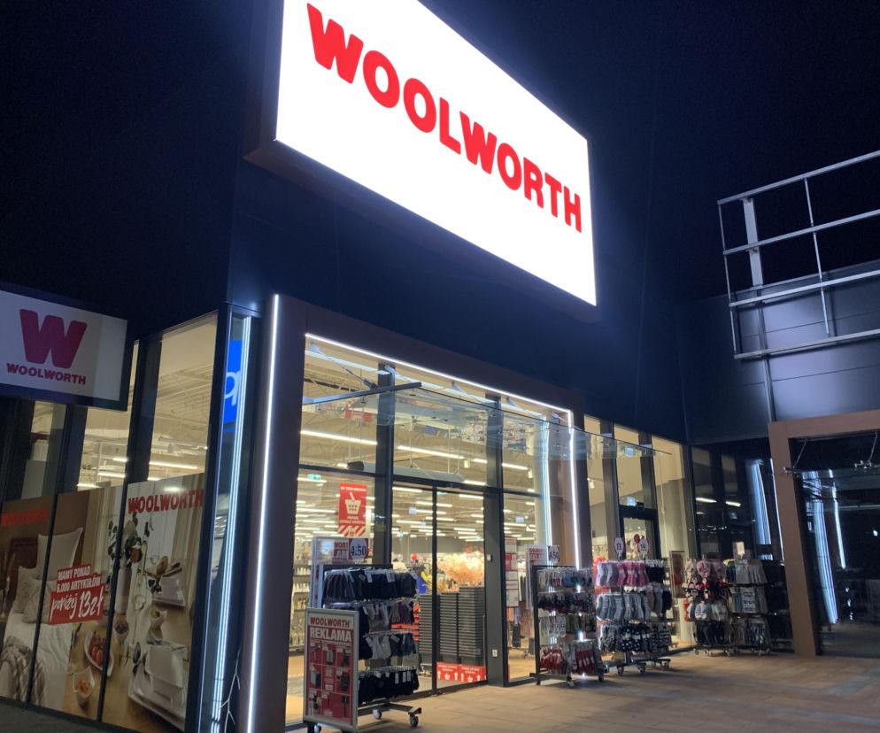 Wejście do sklepu Woolworth w nocy z podświetlonym szyldem. O przejęciu sieci przez TEDi przeczytasz na SE Superbiz.