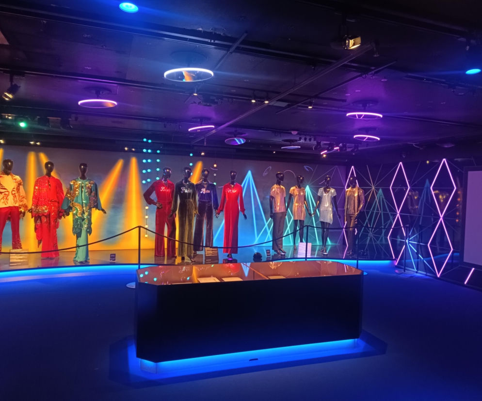 Manekiny w kolorowych kostiumach scenicznych w Muzeum ABBY. O historii hitu Dancing Queen przeczytasz na Eska.