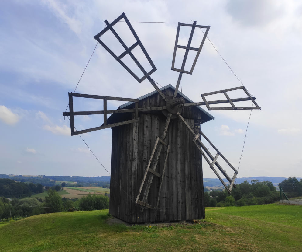 Drewniany wiatrak w Różance na tle panoramy Podkarpacia. O miejscach wartych zobaczenia jesienią przeczytasz na SE.