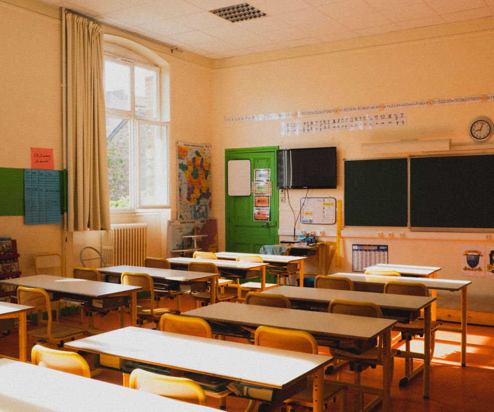Pusta sala lekcyjna z rzędami żółtych ławek. O nowym przedmiocie edukacja zdrowotna przeczytasz w serwisie Eska.
