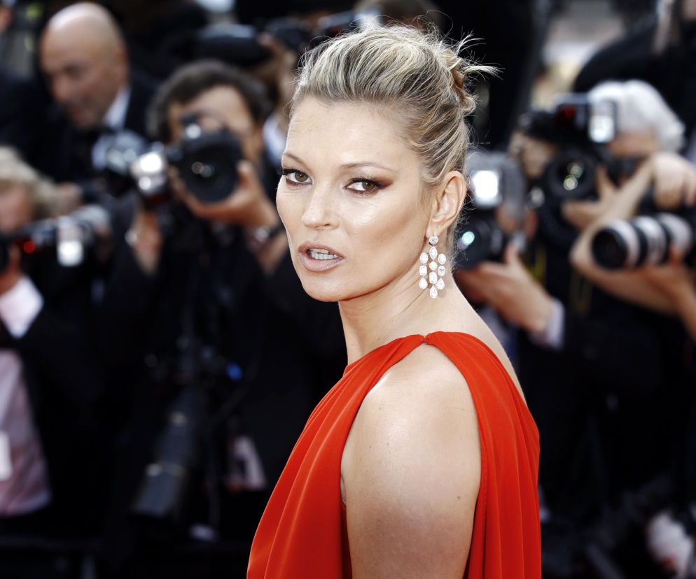 Kate Moss w czerwonej sukni na tle tłumu fotoreporterów. O skandalach z udziałem modelki przeczytasz na Eska.