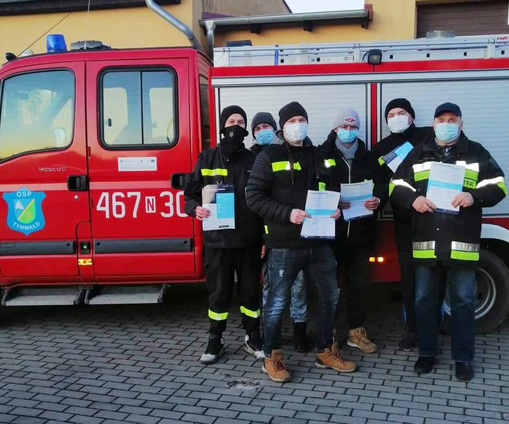 Strażacy z OSP dostarczają ulotki na temat szczepień do mieszkańców powiatu iławskiego