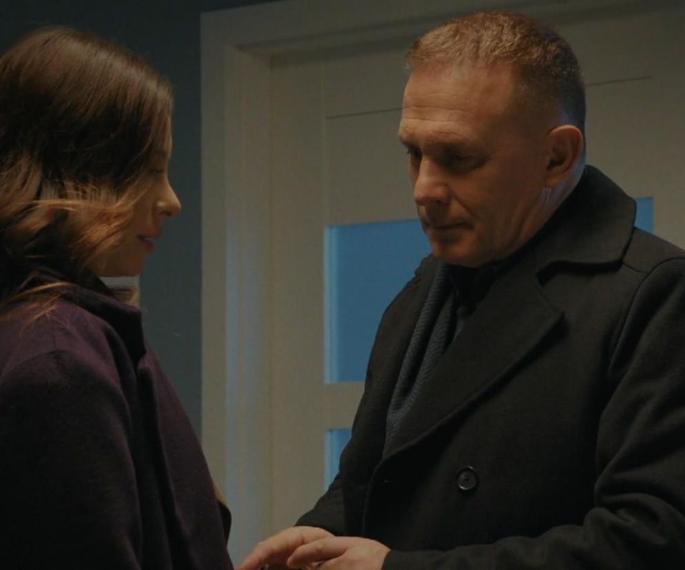 Robert Moskwa jako Artur Rogowski i Dominika Sakowicz jako Joanna w 1926 odcinku M jak miłość. Artur patrzy z troską na Joannę, która uśmiecha się delikatnie. Scena ma miejsce w pomieszczeniu, prawdopodobnie w przychodni. O najnowszych wydarzeniach z serialu przeczytasz na Super Seriale.