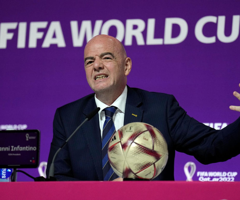 Prezydent FIFA Gianni Infantino przemawia gestykulując przy stole z piłką. O konflikcie w federacji czytaj w SE Supersport.