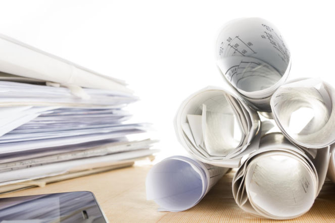 Stos zrolowanych projektów budowlanych i dokumentacji