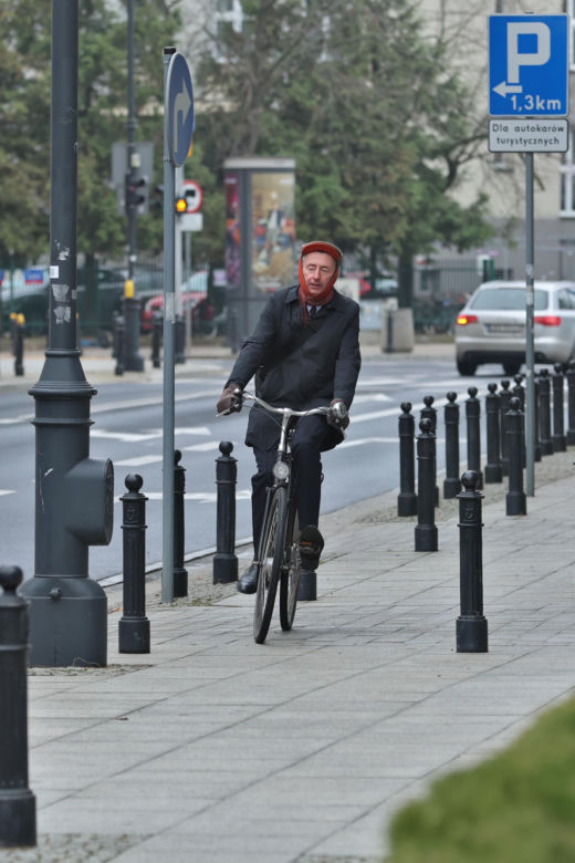 Maciej Gdula na rowerze. Chroni uszy przed chłodem