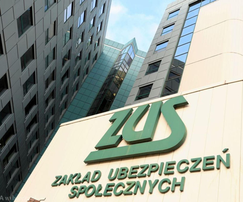 Logo Zakładu Ubezpieczeń Społecznych (ZUS) w kolorze zielonym na tle nowoczesnego budynku biurowego, symbolizujące kwestie rocznego rozliczenia składki zdrowotnej oraz zwrotu nadpłaty, o których przeczytasz więcej na Super Biznes.
