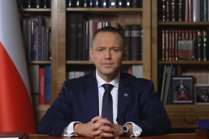 Prezydent Karol Nawrocki przy biurku na tle flagi Polski. O podpisanych przez niego ustawach przeczytasz na SE Superbiz.