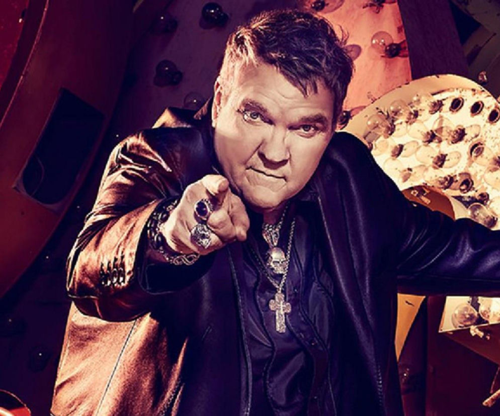 Meat Loaf w ciemnej marynarce wskazuje palcem przed siebie. O jego karierze aktorskiej przeczytasz na EskaRock.