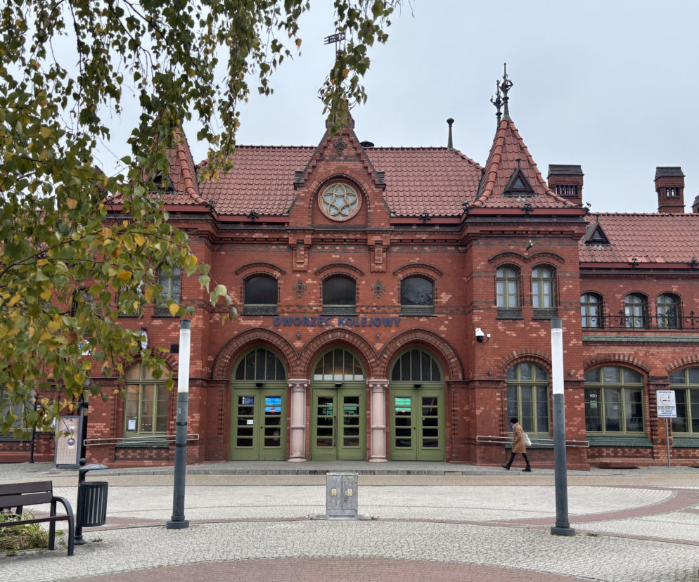 Zabytkowy ceglany dworzec kolejowy w Malborku z wieżyczkami. O architekturze miasta przeczytasz w serwisie Architektura.