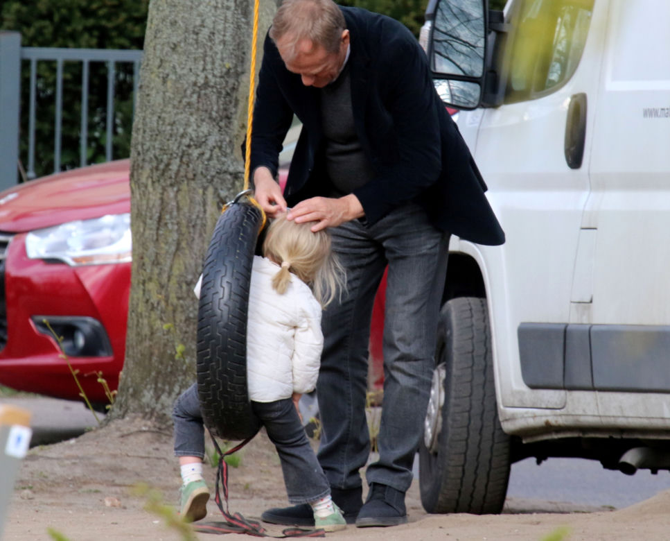Donald Tusk z wnuczka na placu zabaw