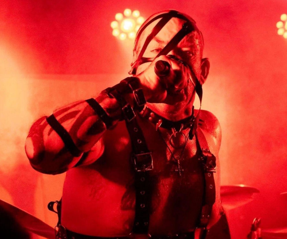 Anders Colsefni śpiewa do mikrofonu w czerwonym świetle reflektorów. O byłym wokaliście Slipknot czytaj w EskaRock.