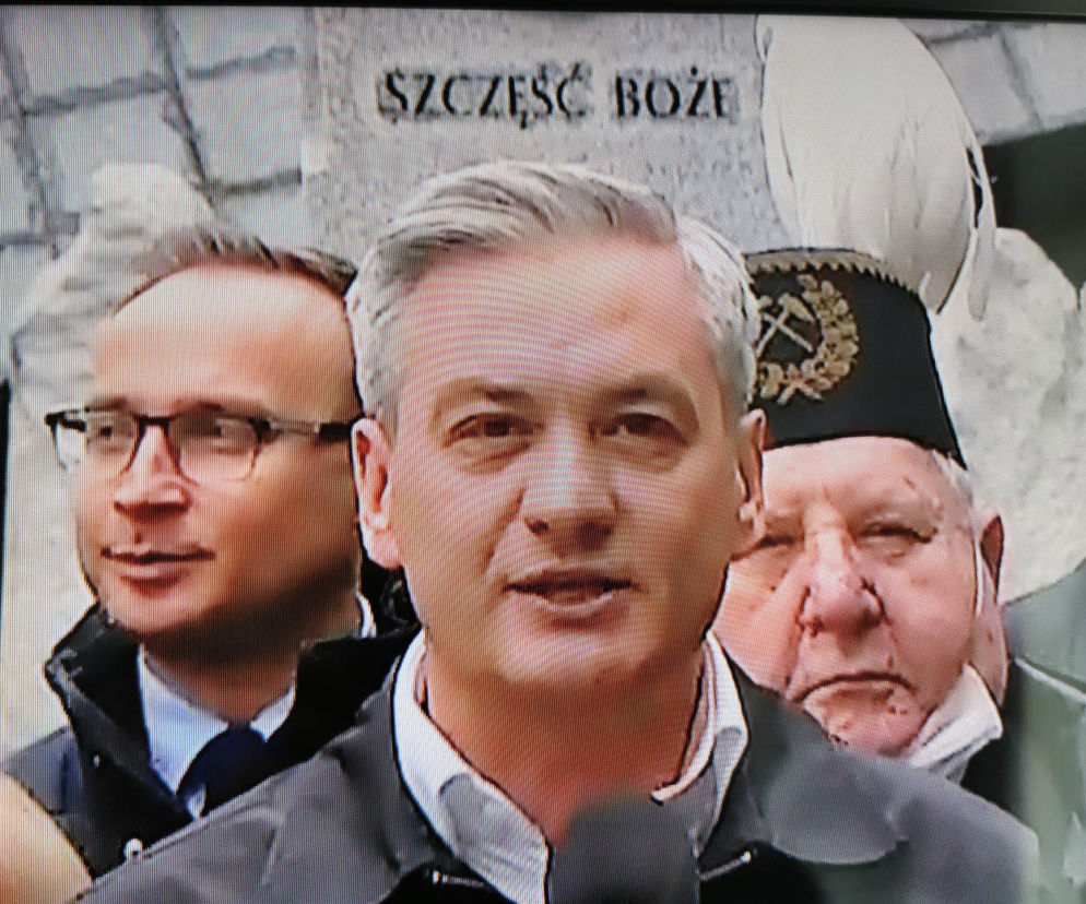 Robert Biedroń na tle religijnego hasła