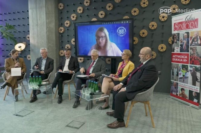 Panel dyskusyjny z udziałem sześciu ekspertów, w tym kobiety przemawiającej do mikrofonu i osoby na telekonferencji, omawiający konieczność zmian w Prawie farmaceutycznym, by apteka stała się pełnoprawnym ogniwem systemu ochrony zdrowia. Więcej na ten temat przeczytasz na Poradnik Zdrowie.