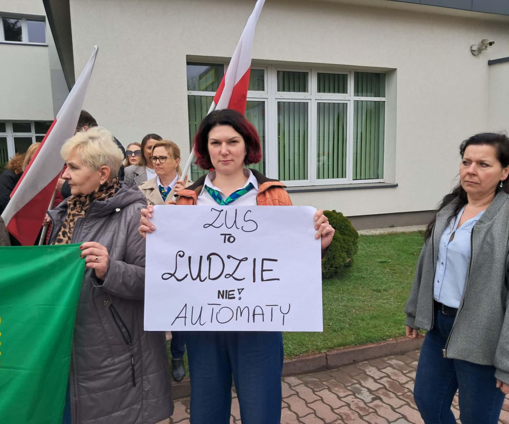 Kobieta trzyma transparent z napisem ZUS to ludzie nie automaty. O sporze o pensje w ZUS przeczytasz na portalu Eska.