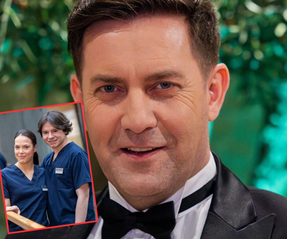 Uśmiechnięty aktor Tomasz Mandes w czarnym smokingu z muchą. W tle nałożone jest prostokątne zdjęcie Julity i Floriana Kochańskiego w ciemnoniebieskich strojach medycznych. O ich walce o karierę w klinice przeczytasz na portalu Super Seriale.