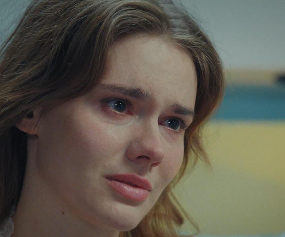 Zbliżenie na zapłakaną Frankę (Dominika Kachlik) z serialu M jak miłość. Ma zaczerwienione oczy, jasnobrązowe włosy lekko opadają na ramiona. Wyraża smutek i bezsilność w obliczu diagnozy tętniaka aorty. Więcej o dramacie Franki na portalu Super Seriale.