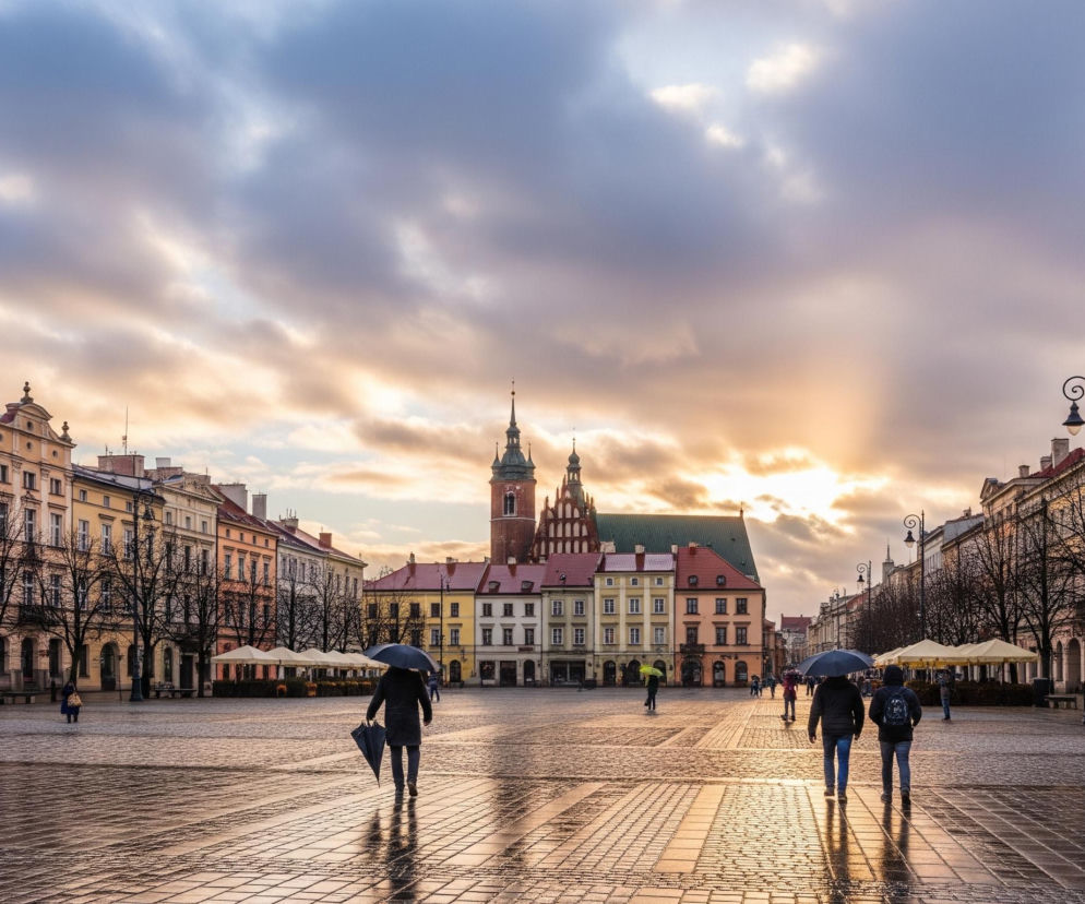 Główną część obrazu zajmuje rozległy, brukowany plac, lśniący od deszczu, odbijając światło zachodzącego słońca. Na pierwszym planie widać trzy osoby idące tyłem do widza, dwie z nich trzymają rozłożone parasole, a jedna złożony. Po obu stronach placu wznoszą się rzędy starych, wielopiętrowych kamienic o różnobarwnych fasadach, z widocznymi drzewami bez liści przed nimi. W tle, na wprost, dominuje budynek z wysokimi spiczastymi wieżami i zielonym dachem, otoczony innymi kamienicami. Nad całością rozciąga się niebo pokryte chmurami, przez które przebijają się intensywne promienie zachodzącego słońca, tworząc złociste smugi.