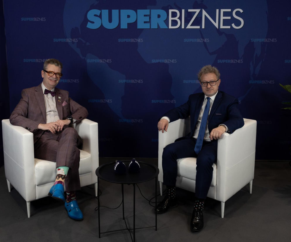 Hubert Biskupski i prof. Piotr Wachowiak w studio Super Biznes, siedzący w białych fotelach na tle ściany z logo Super Biznes, rozmawiający o wyzwaniach polskiej gospodarki i jej pozycji w G20.