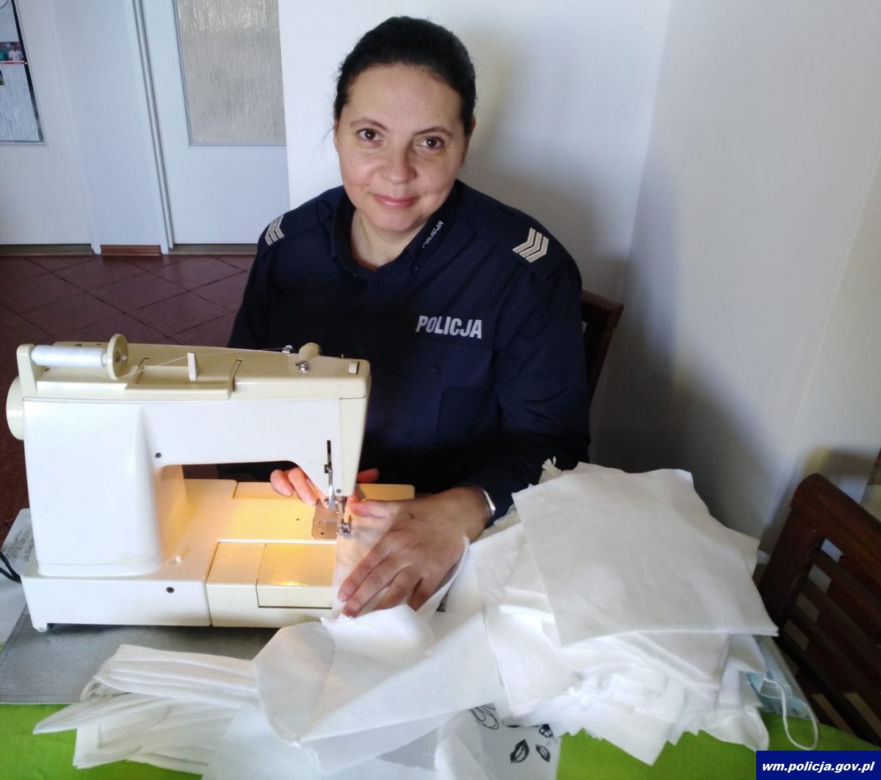 Policjantka z piskiej komendy sierż. szt. Małgorzata Księżyk szyje maseczki ochronne