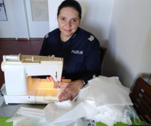 Policjantka z piskiej komendy sierż. szt. Małgorzata Księżyk szyje maseczki ochronne