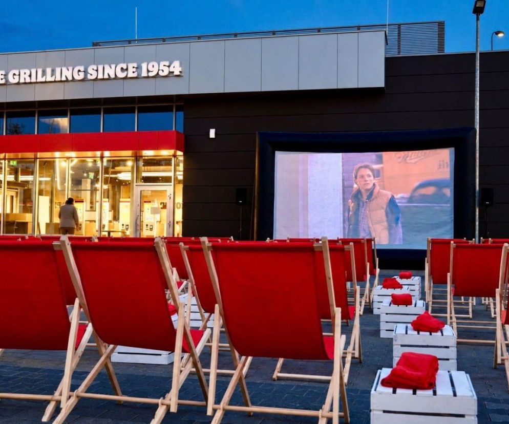 Kino plenerowe Burger King w Zgorzelcu. Rzędy leżaków przed ekranem z filmem Powrót do przyszłości. Więcej na Eska.
