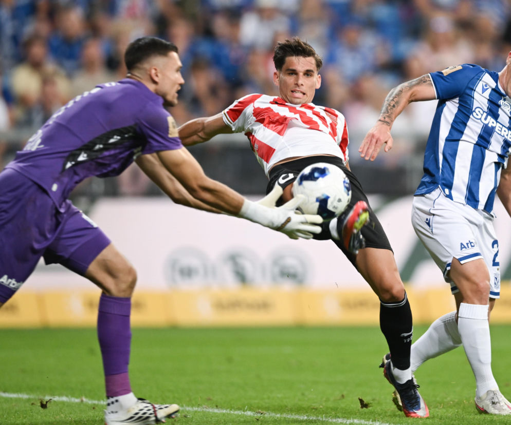 Trzej piłkarze walczący o piłkę na boisku. O meczach Lecha Poznań i Górnika Zabrze przeczytasz na SE Supersport.