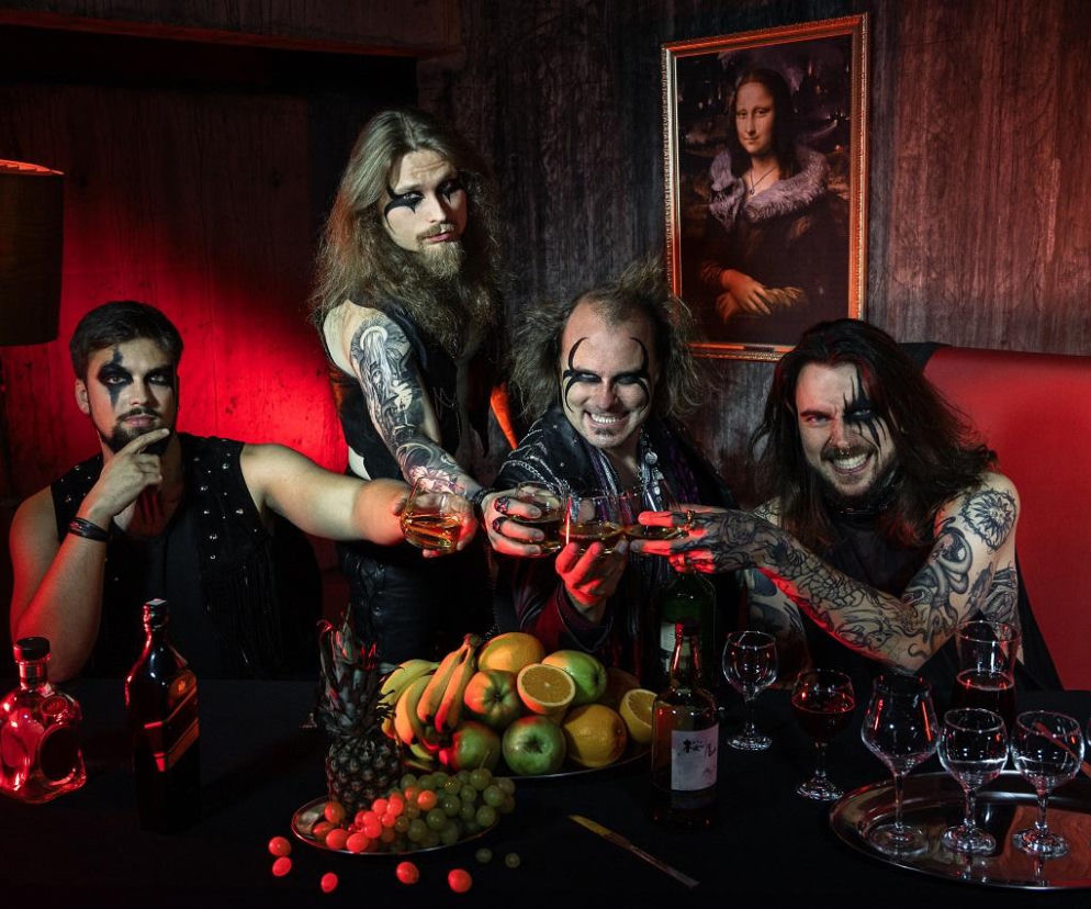 Muzycy Sick Saints z mrocznym makijażem przy stole z owocami i alkoholem. O nowym singlu zespołu przeczytasz na EskaRock.