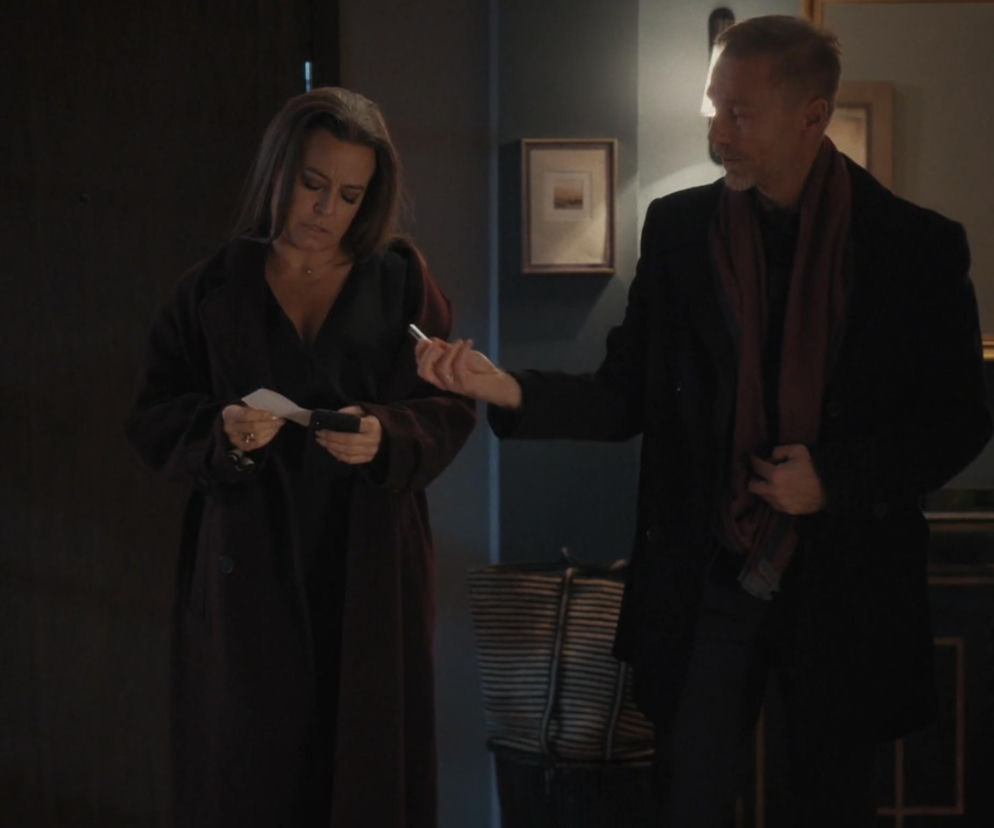 Magda (Anna Mucha) w ciemnym płaszczu trzymająca kartkę i telefon, obok Andrzej Budzyński (Krystian Wieczorek) w czarnym płaszczu i bordowym szaliku, podający jej coś. Scena z serialu M jak miłość z odcinka 1928, pełne informacje o fabule na Super Seriale.