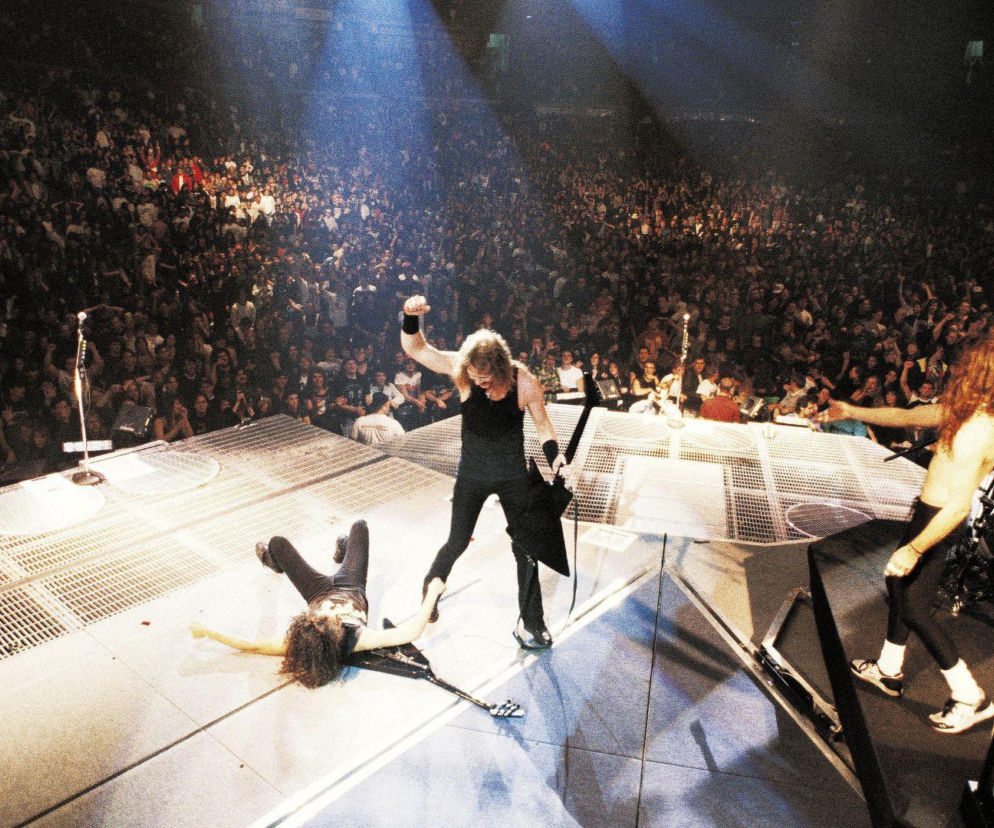 Zespół Metallica na scenie podczas koncertu przed tłumem fanów. O ocenach ich płyt przeczytasz na EskaRock.