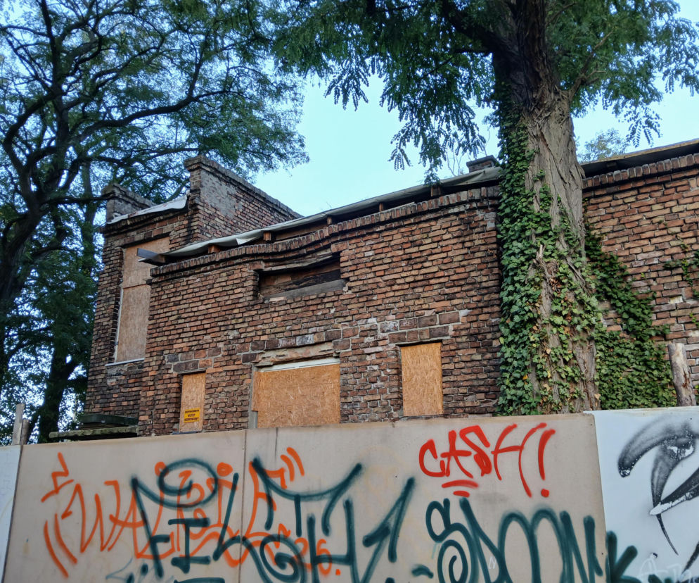 Ceglane ruiny domu przy Ryżowej 80 w Warszawie za ogrodzeniem z graffiti. O historii budynku przeczytasz w Architektura.