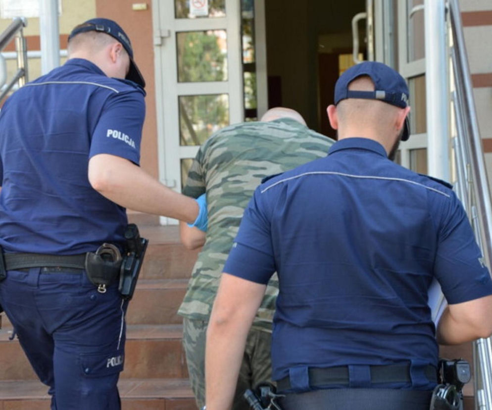 Dwaj policjanci wprowadzają mężczyznę do budynku sądu. O wyroku dla oprawcy z Gaików przeczytasz na Eska Leszno.