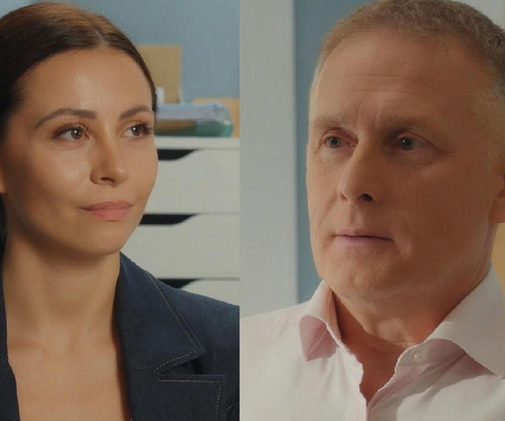 Zbliżenie na twarze Joanny (Dominika Sakowicz) i Artura (Robert Moskwa) z serialu M jak miłość. Joanna, z ciemnymi włosami, w granatowej marynarce, spogląda w prawą stronę. Artur, w jasnej koszuli, patrzy przed siebie. Scena sugeruje intrygę i szpiegowanie, o czym przeczytasz na Super Seriale.