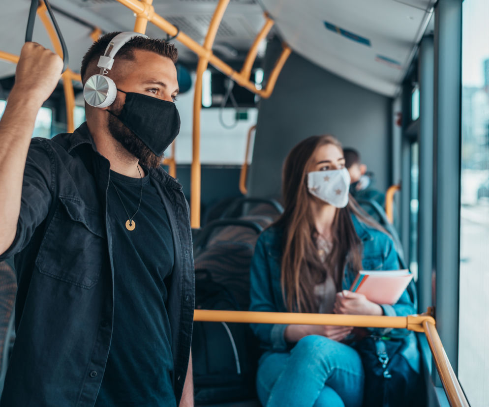 Ludzie w maseczkach jadą autobusem