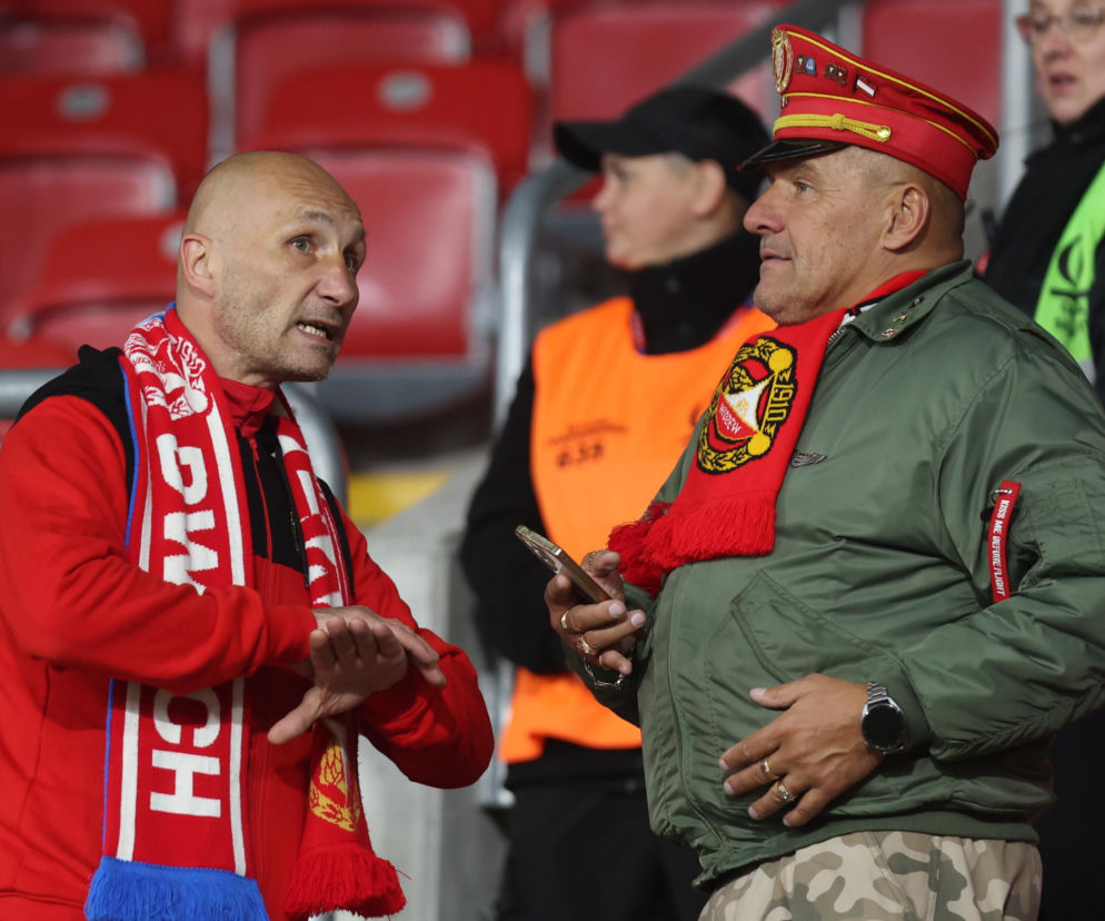 Dwaj rozmawiający kibice Widzewa Łódź na trybunach. O atmosferze meczu z Górnikiem Zabrze przeczytasz na Eska Łódź.