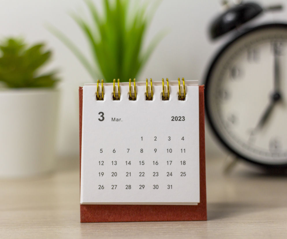 Kalendarz biurkowy na marzec 2023 r. z widocznym dzwonkiem budzika w tle, symbolizujący upływający czas i ważne terminy procesowe w sporach frankowych. Informacje o wyroku TSUE zmieniającym zasady rozliczeń z frankowiczami znajdziesz na portalu Super Biznes.