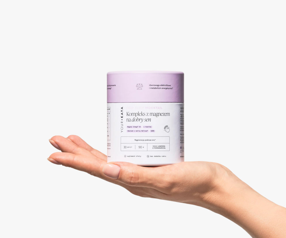 Dłoń trzymająca fioletowo-białe opakowanie suplementu diety Your KAYA Deep Sleep Mocktail, kompleksu z magnezem na dobry sen, o smaku lawendy z pomarańczą. Produkt wspiera regenerację organizmu, a więcej o nim przeczytasz na naszym portalu.